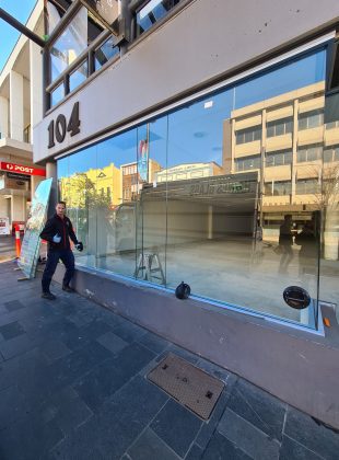 A glazier in front of a commercial building